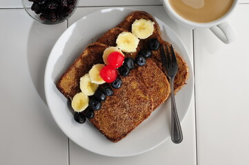 breakfast with french toast with sugar and cinnamon and slices of banana, blackberries and cherries...