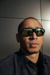 Obraz premium Portrait angry man screaming in studio. Closeup african american guy shouting on black background. Male model aggressive face expression. Serious man take off sunglasses.