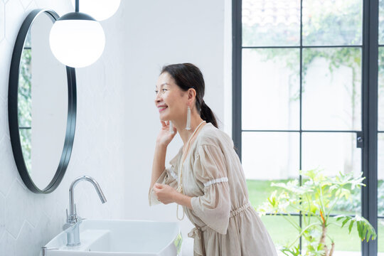 洗面所で身だしなみを整えるシニア女性