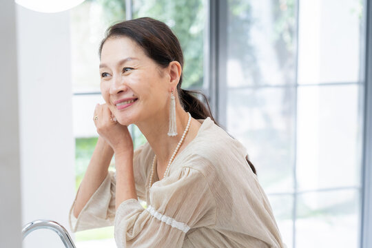 洗面所で身だしなみを整えるシニア女性