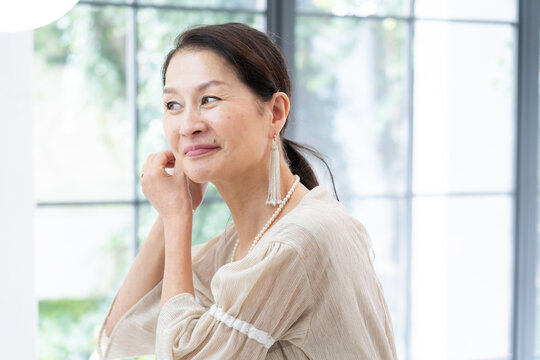 洗面所で身だしなみを整えるシニア女性