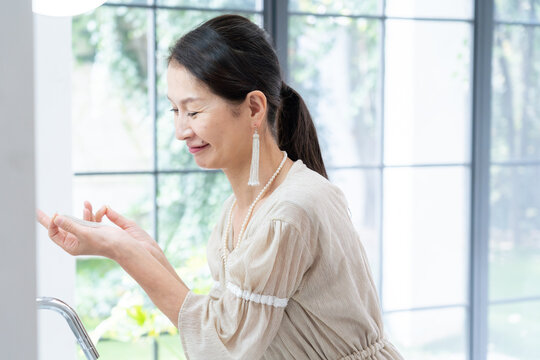 洗面所で身だしなみを整えるシニア女性
