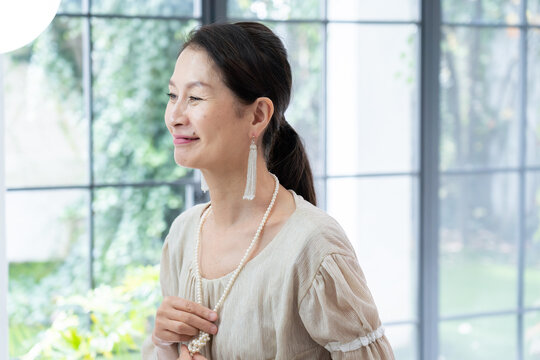 洗面所で身だしなみを整えるシニア女性