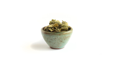 Comfrey Leaves that are Dried in Green Pottery Bowl Isolated on White