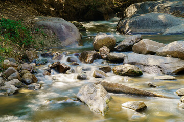 Fototapeta na wymiar Water flowing along rocks in nature, waterfall