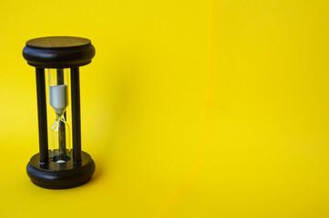 Minute glass isolated on yellow background. Copy space concept