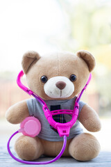 Vertical photo Brown teddy bears wore a stethoscope around the neck. Health care concept. And free...