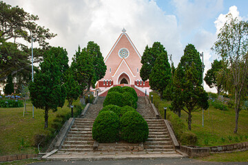 Mai Anh Domaine De Marie Church diocese on blue sky background, hidden behind pine tree on sunny day with front view, located in Da Lat, Lam Dong province, Vietnam