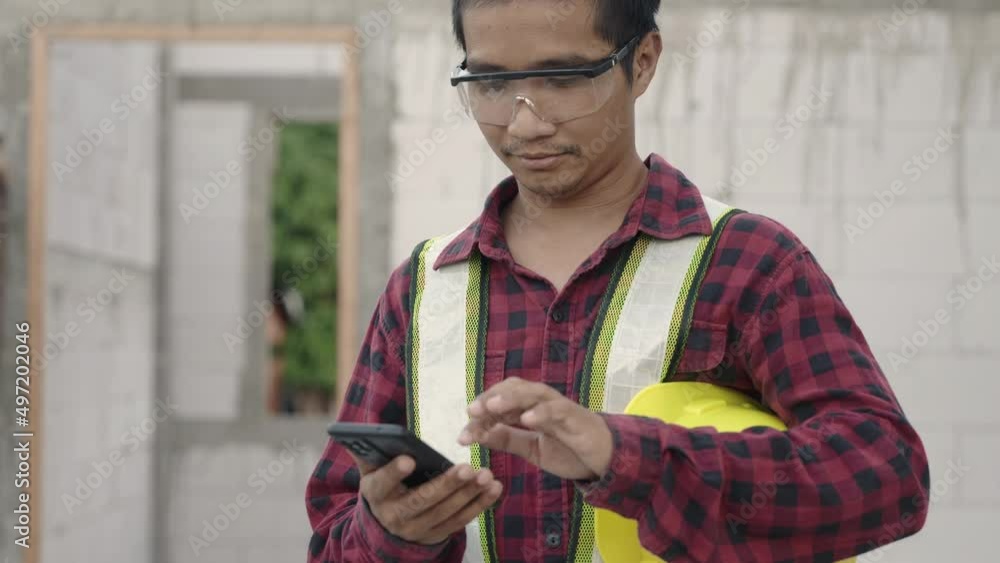 Poster asian architect engineer worker man in protective helmet and uniform using smart phone mobile app wi