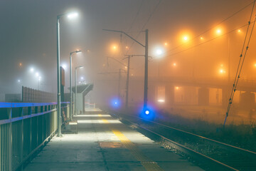 Foggy scene with empty railway station and lighting. Mystical foggy industrial background
