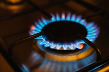 a fire lights up in the burner of the gas stove. A stove uses combustible or natural gas from the city gas network or liquefied gas as fuel. the energy crisis and rising energy prices. 