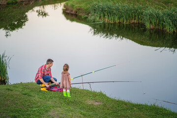 A young man and a little girl are actively spending time near the lake.