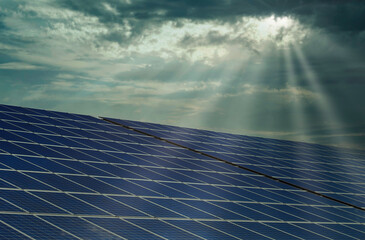 solar panels with sunbeams on a cloudy day