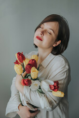 Portrait of a girl with a bouquet of tulips.
