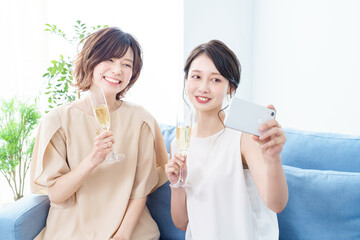シャンパングラスを手に撮影する女性2人 © maru54