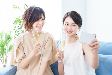 シャンパングラスを手に撮影する女性2人 © maru54