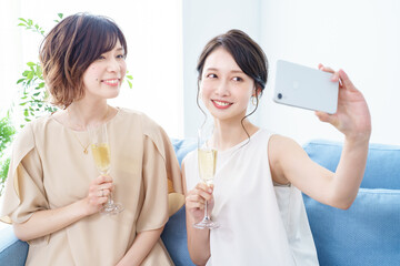 シャンパングラスを手に撮影する女性2人 © maru54