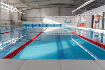 Obraz premium A male athlete swims in a swimming pool sports complex in blue water.