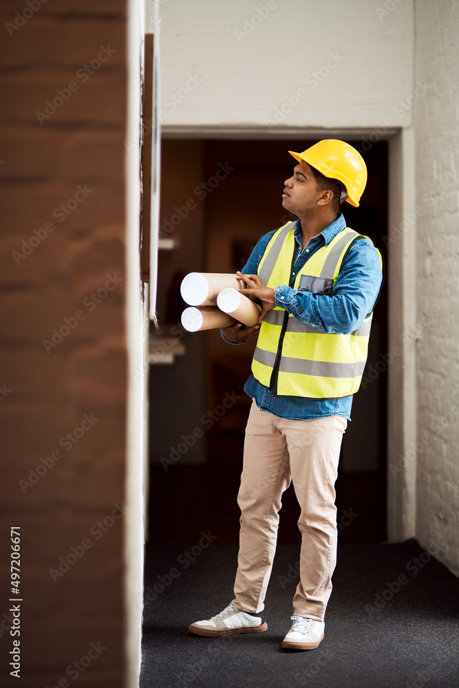 Poster Ready to get this project rolling. Shot of a young engineer reading something on a wall.