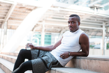 Fototapeta premium Runner drinking water while resting after workout.
