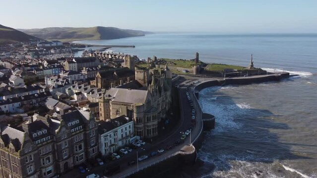 An aerial view of the the Welsh town of Aberystwyth. Flying over the pier away from the castle and war memorial on a sunny spring morning, Ceredigion, Wales, UK.