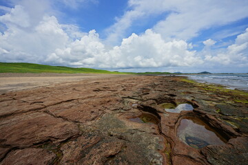 Fototapeta premium rock beach and charming clouds