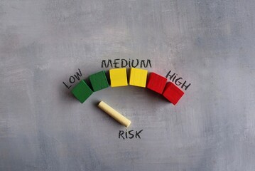Colorful wooden cubes and chalkboard. Risk indicator, risk meter concept. Risk level low.
