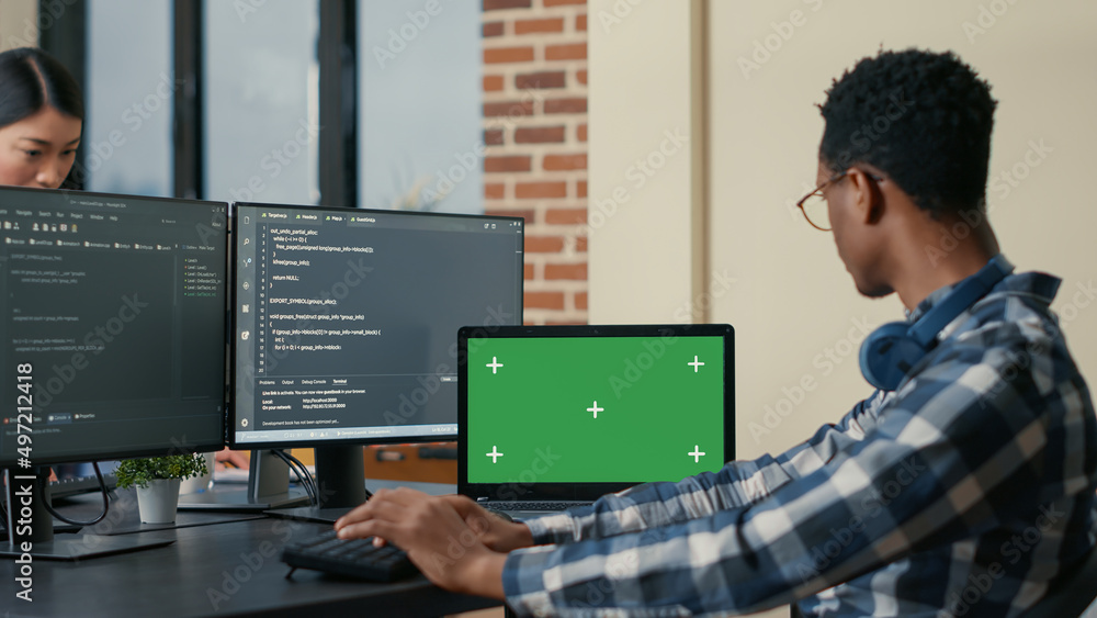 Poster software developer writing code using computer keyboard and laptop with green screen chroma key mock