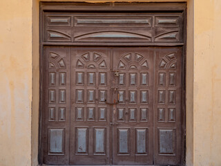 Antique brown wooden door with locks and bolts.
