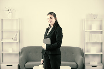 Young businesswoman holding notebook with too much work in office. Secretary girl.
