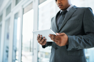 Who has time to be tied to their desk. Shot of a businessman using a digital tablet in a modern office.