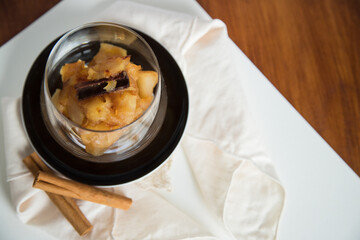 Caramelized apple dessert on wooden table. Baked or roast apple with cinnamon.