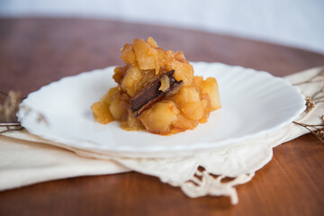 Caramelized apple dessert on wooden table. Baked or roast apple with cinnamon.