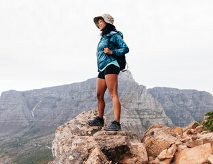 Woman hiker standing on a rock and enjoying the view
