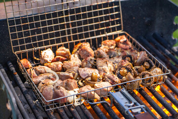Pork skewers and mushrooms are cooked over an open fire. 
