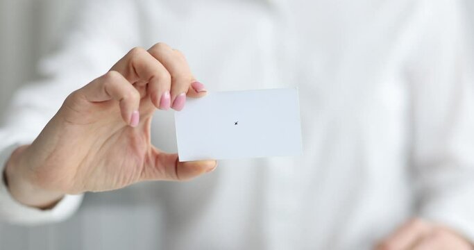 Businessperson shows white business card at meeting.