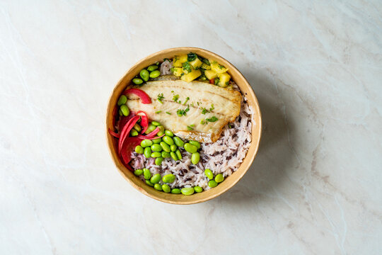 Sea Bass Fillet Fish Poke Bowl With Edamame Beans, Basmati Rice, Onion Pickle And Chopped  Pineapple Cube In Take Away Plastic Take Out Box Container Package.