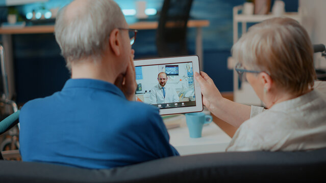 Elder patients with toothache using videocall to talk to dentist on digital tablet. Senior people calling orthodontist on remote teleconference to chat about dental care, holding gadget.