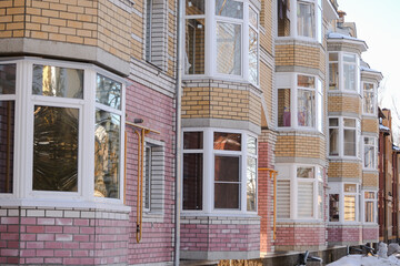 Obraz premium New apartment building with glass balconies. Modern architecture houses. Large glazing on the facade of the building.