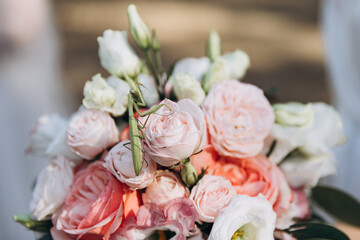 A green praying mantis sits on a wedding bouquet of white and pink flowers with eucalyptus branches