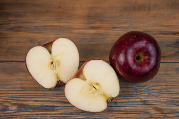 A composition of red apples, cut and whole, on a  wood background. Natural fruits. The half of apple. Space for your text.