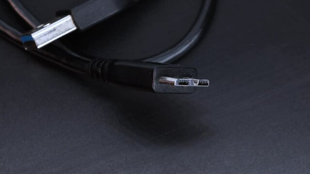 Close up view of ssd hard disk wire cable connector, rotating motion over black background in 4k, macro shot.