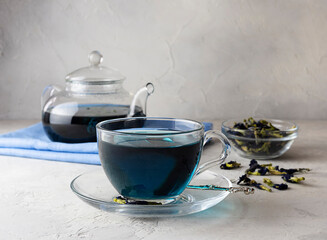 Blue tea from clitoria flowers in a transparent cup on a light table