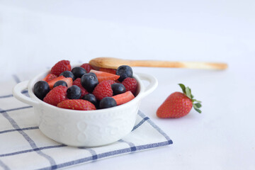 White plate with berries. Light breakfast food photography