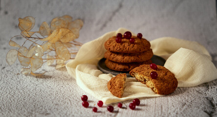 Fototapeta na wymiar Photo with several cookies on a gray ceramic plate with cranberries and dried flowers in the background