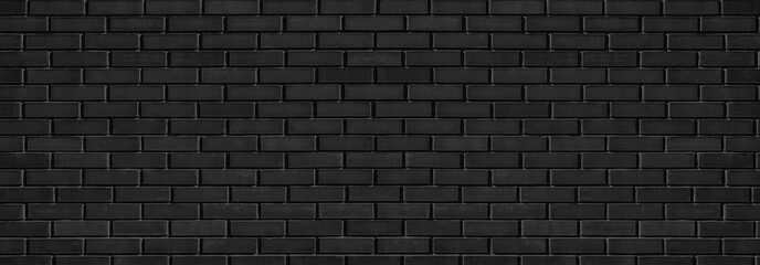 Black shabby brick wall wide texture with hard light. Dark grey brickwork abstract panoramic grunge...