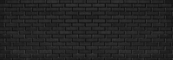 Black shabby brick wall wide texture with hard light. Dark grey brickwork abstract panoramic grunge...