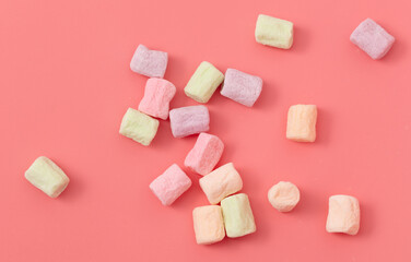 Multicolored candies on a pink background. Close-up