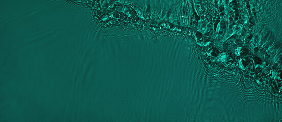 Transparent dark green clear water surface texture with ripples and splashes. Abstract summer banner background Water waves with copy space, top view. Cosmetic moisturizer micellar toner emulsion