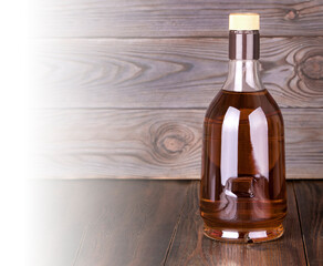 Bottle of whiskey on a wooden background .